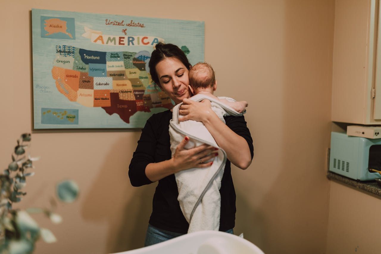 https://www.pexels.com/photo/a-mother-carrying-her-newborn-baby-6849443/